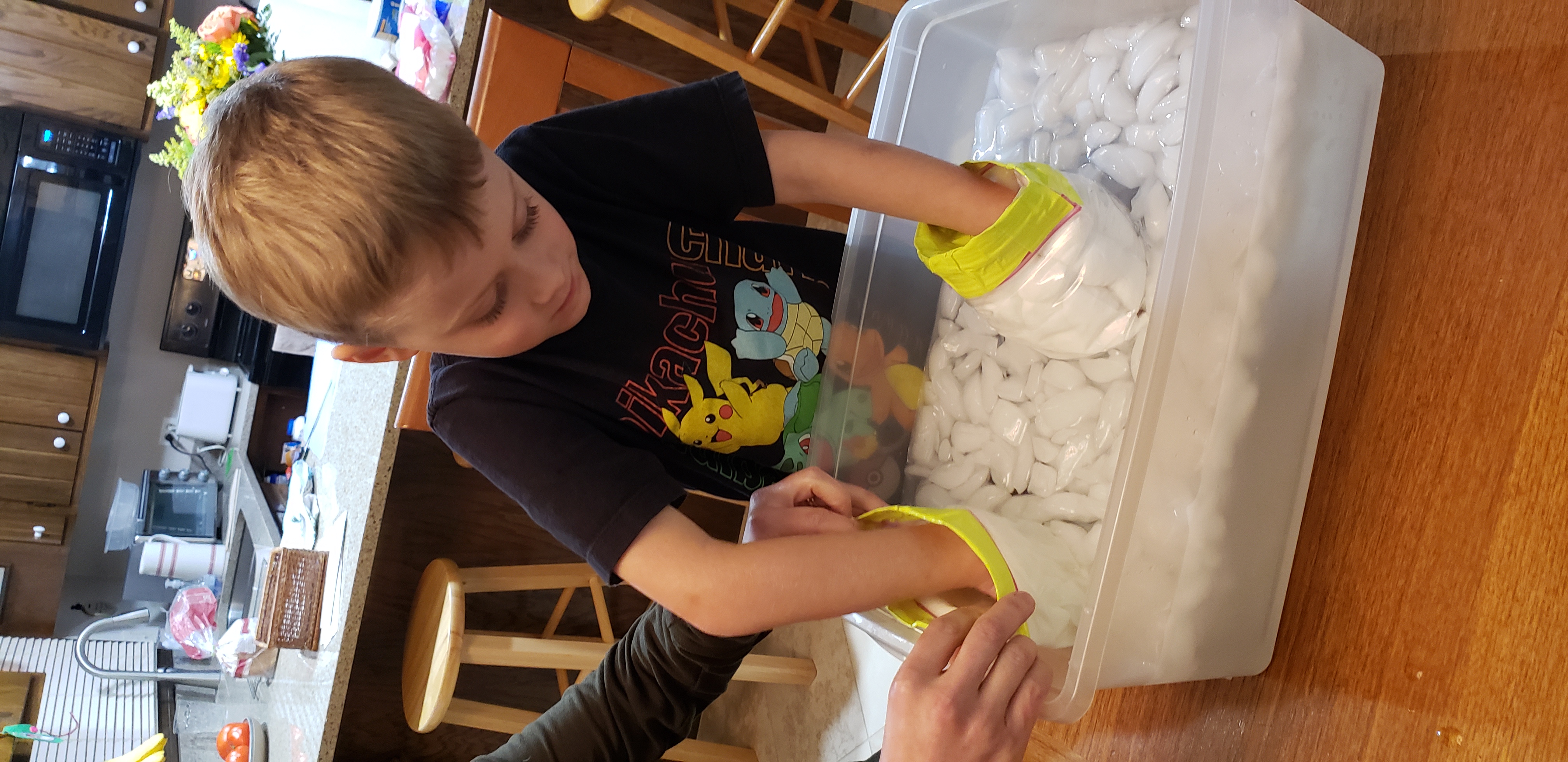 6 year old boy tests material for warmth in an ice bath.