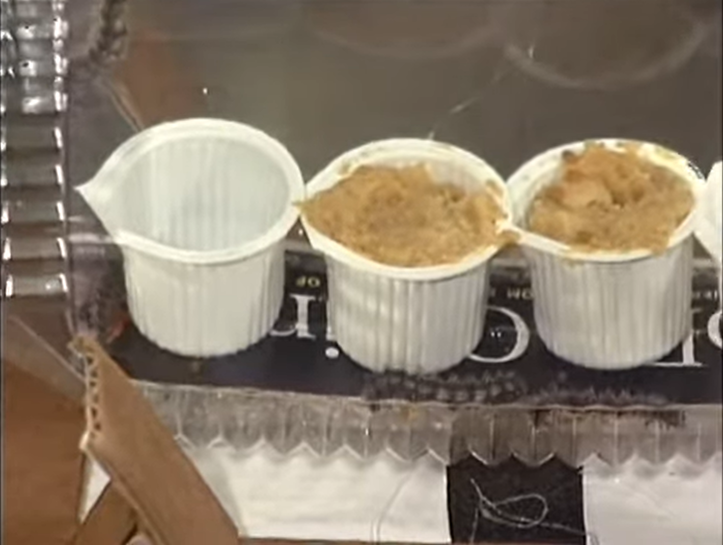 A close up image of the caterpillars in the chamber, with small containers of food for growth.