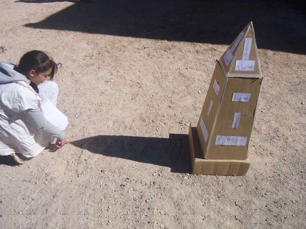 Girl measuring the circumference of the Earth using the Sun and a small obelisk